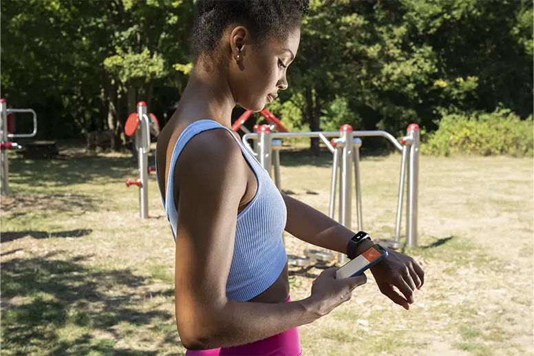 Person wertet den Fitness-Tracker mit Hilfe einer App aus.