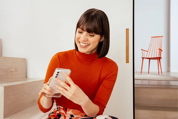 Frau mit Samsung-Handy und -hülle in der Hand.