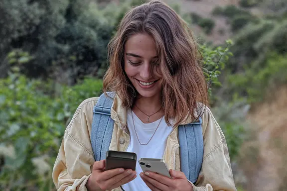 Person bedient ihr Smartphone, während es mit dem Hama Power Pack "PD 20" geladen wird.