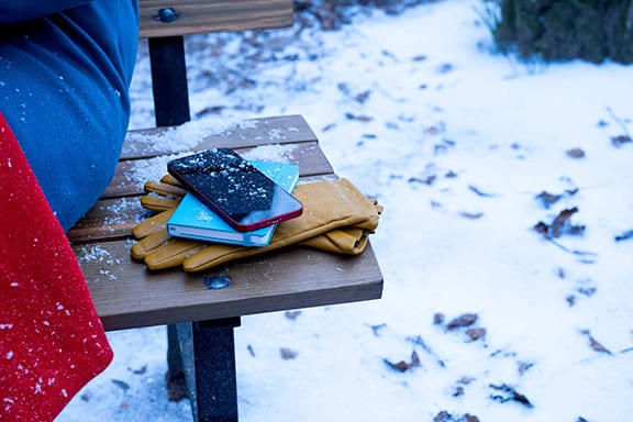 Handy liegt in der Kälte auf einer Parkbank
