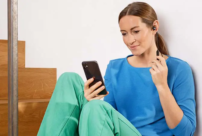 Person beim telefonieren mit Kopfhörern.