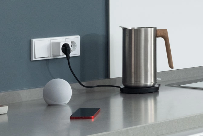 Das Handy liegt neben dem Echo Dot.